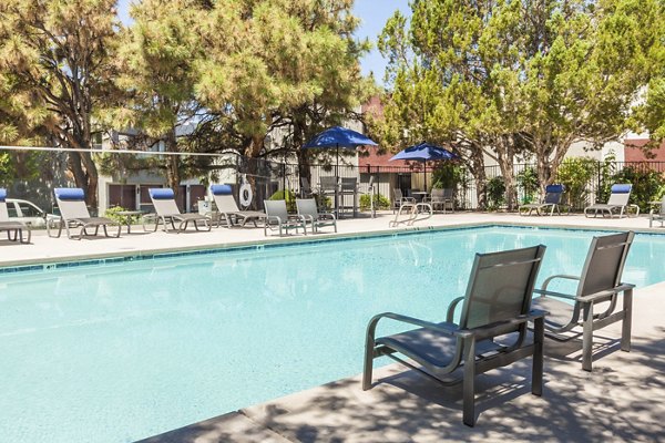 Inviting outdoor pool with sun loungers at The Village at Tierra Antigua Apartments