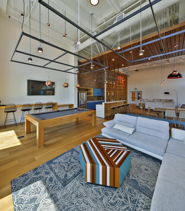 Modern clubhouse with stylish lounge seating and communal kitchen at LA Plaza Village Apartments