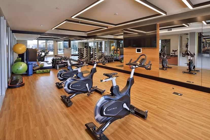 Fitness center at LA Plaza Village Apartments featuring modern equipment and stylish interiors