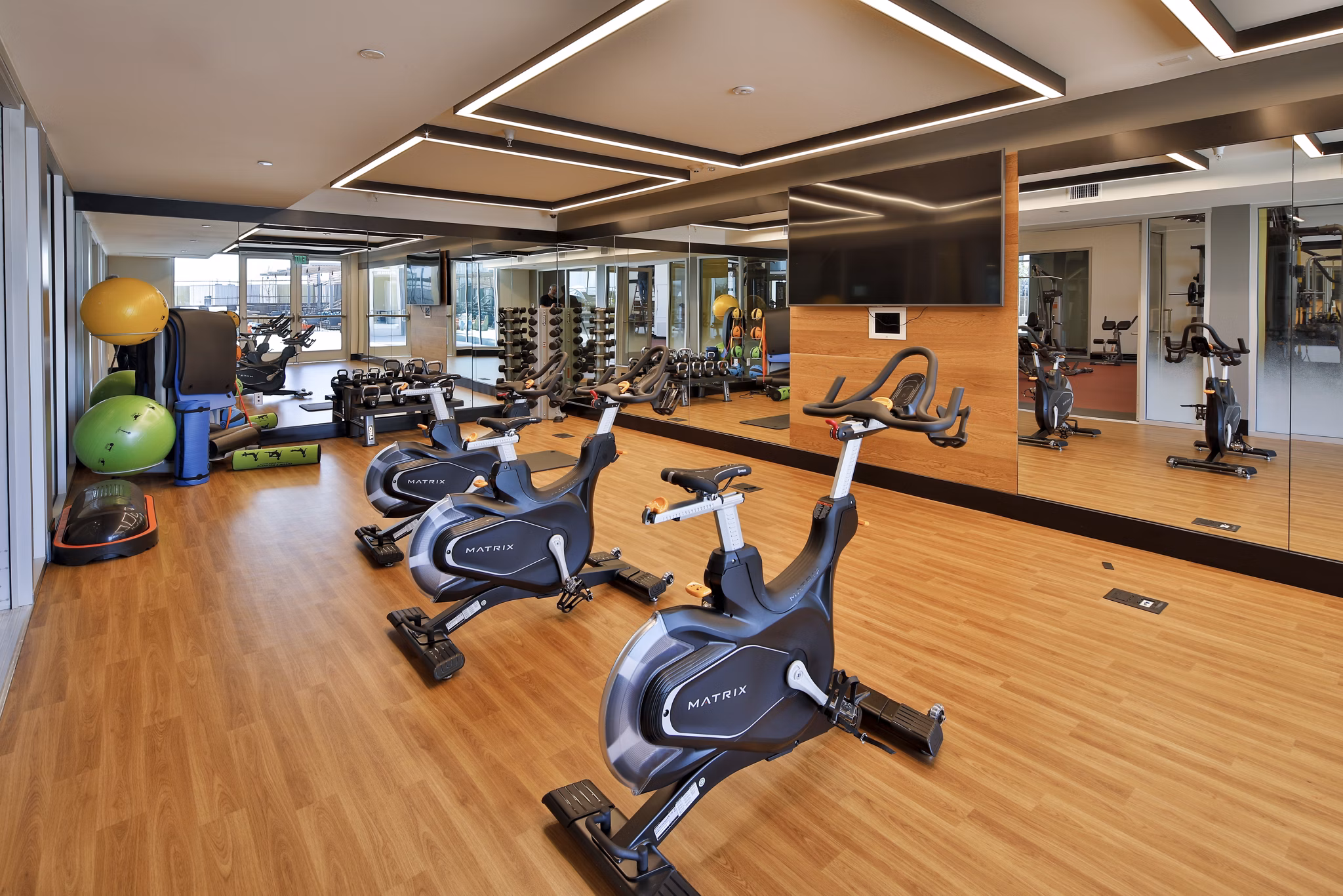 Fitness center at LA Plaza Village Apartments featuring modern equipment and stylish interiors