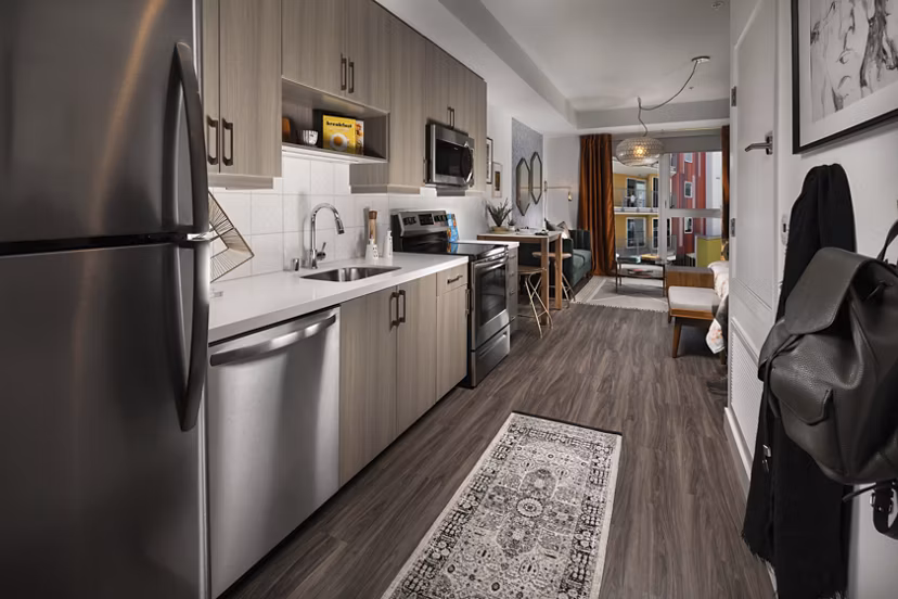 Modern kitchen with marble countertops and stainless steel appliances at LA Plaza Village Apartments