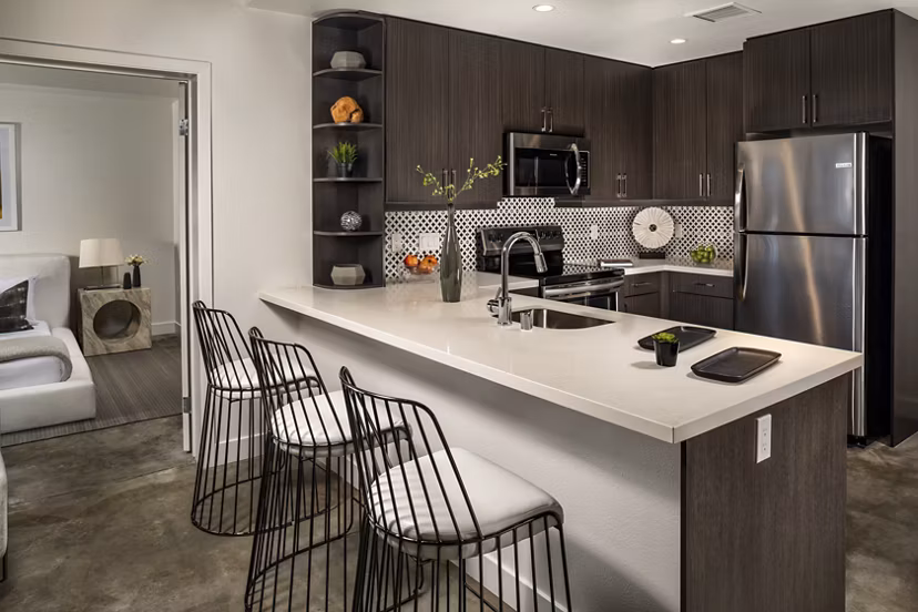 Well-appointed kitchen featuring modern appliances and sleek countertops at LA Plaza Village Apartments, a Greystar luxury community