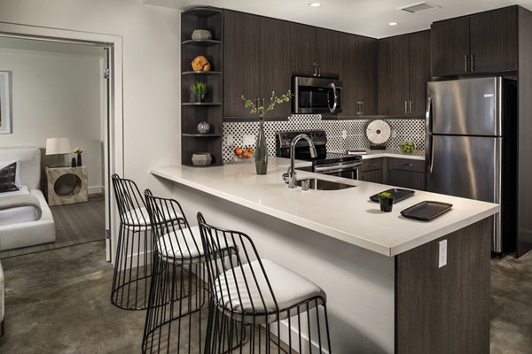 Well-appointed kitchen featuring modern appliances and sleek countertops at LA Plaza Village Apartments, a Greystar luxury community