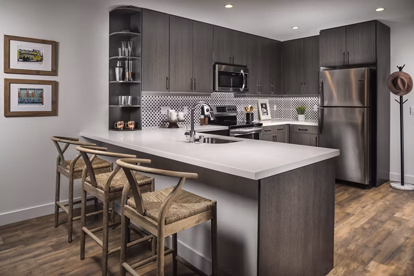 Modern kitchen with stainless steel appliances at LA Plaza Village Apartments