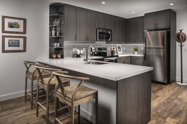Modern kitchen with stainless steel appliances at LA Plaza Village Apartments