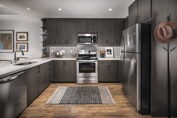 Modern kitchen with stainless steel appliances at LA Plaza Village Apartments