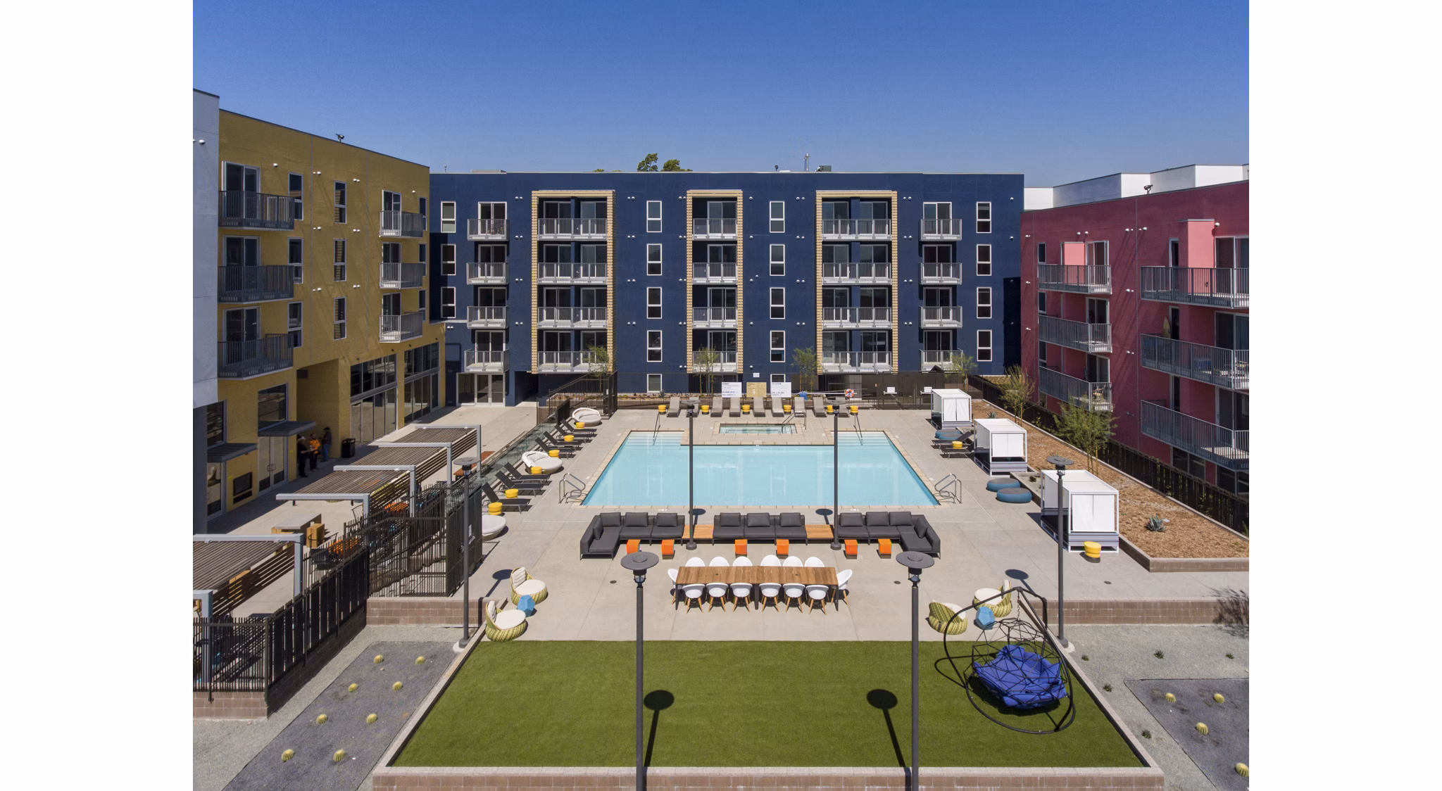 Resort-style pool with loungers at LA Plaza Village Apartments in downtown Los Angeles
