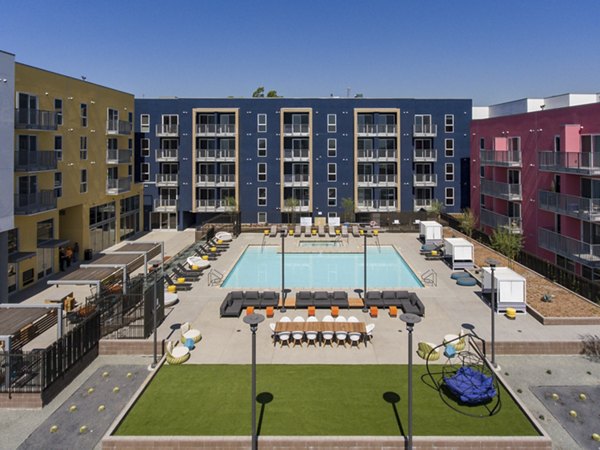 Resort-style pool with loungers at LA Plaza Village Apartments in downtown Los Angeles