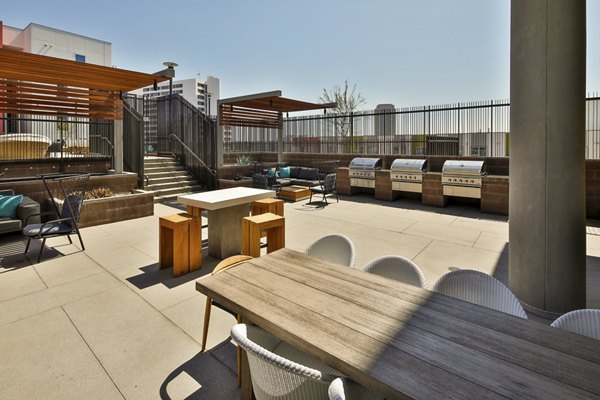 Outdoor grilling area with modern stainless-steel BBQs at LA Plaza Village Apartments