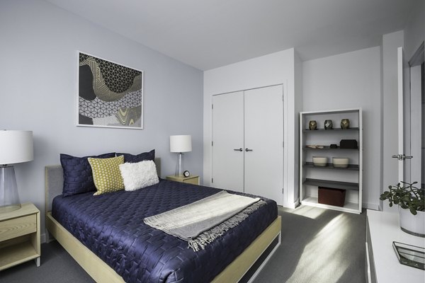 Modern bedroom with large windows at Union House Apartments, offering luxury living in a sleek design