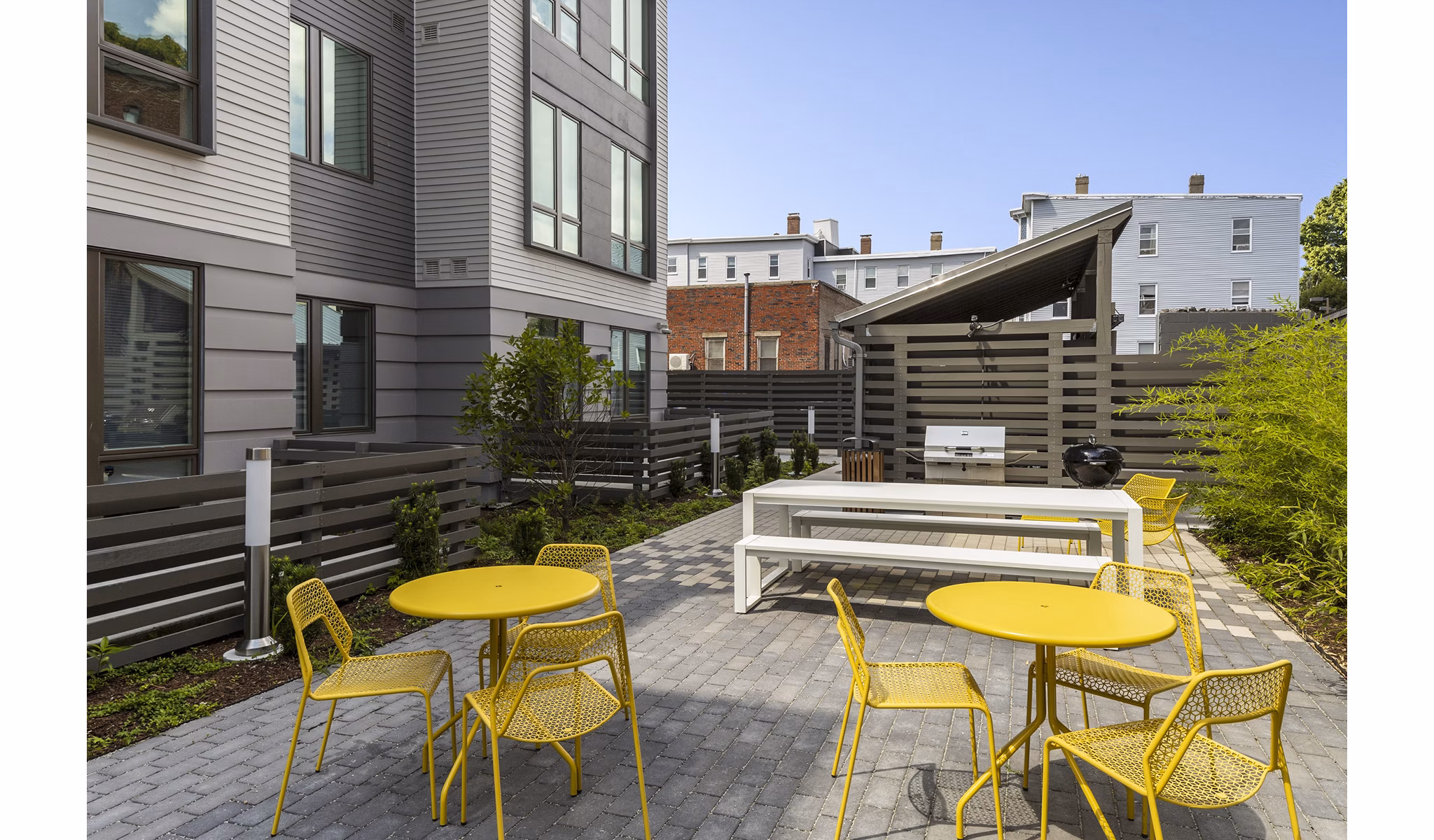 Outdoor grill area with seating at Union House luxury apartments, perfect for social gatherings in a stylish community setting