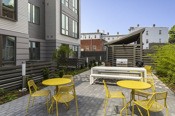 Outdoor grill area with seating at Union House luxury apartments, perfect for social gatherings in a stylish community setting