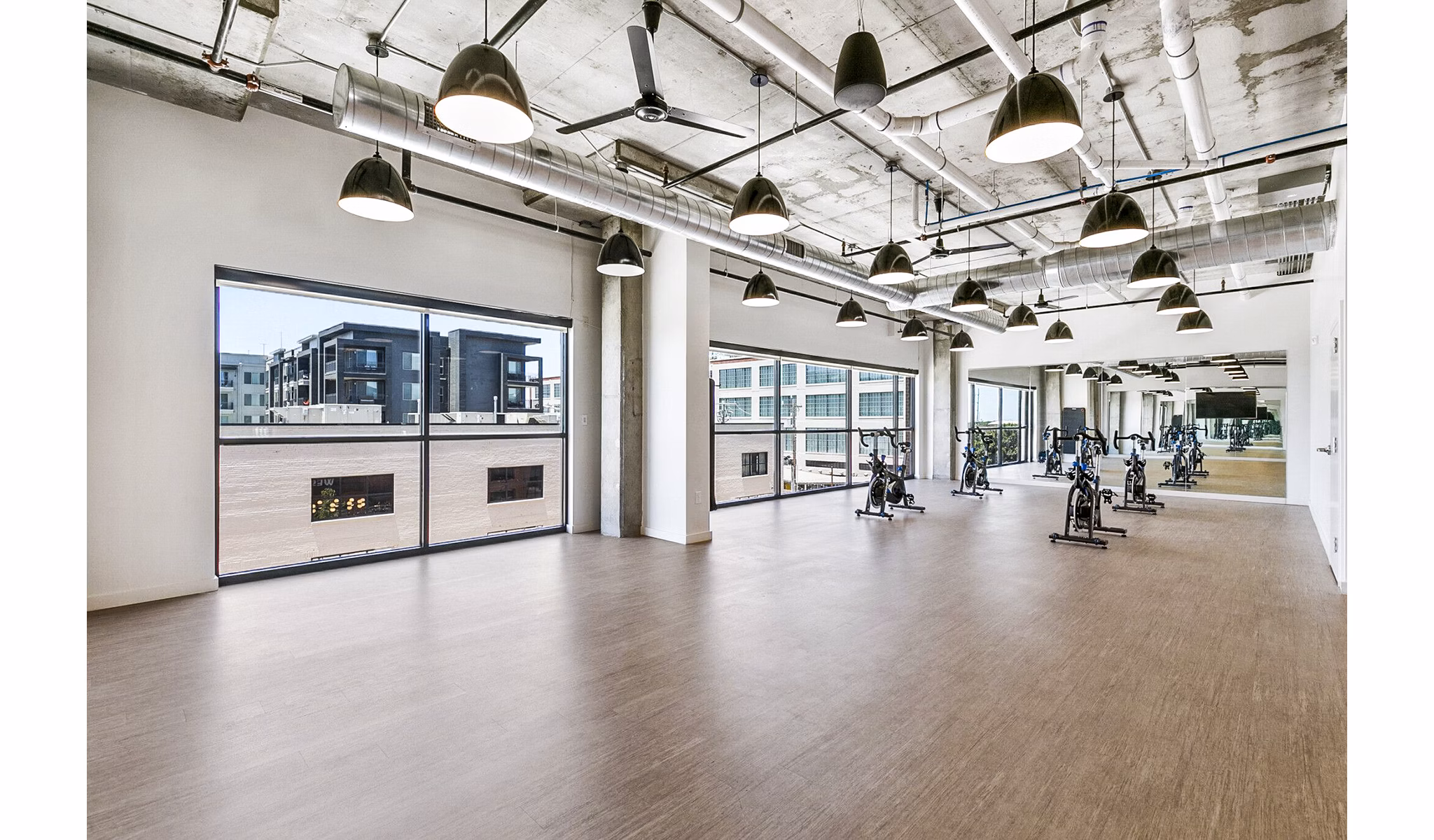Yoga and spin studio equipped with modern fitness gear at West Village Apartments