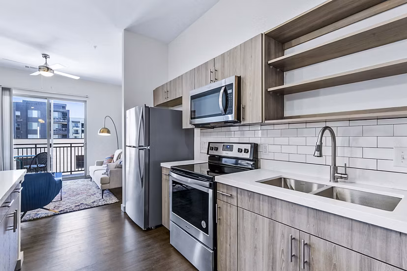 Modern kitchen with stainless steel appliances at West Village Apartments by Greystar