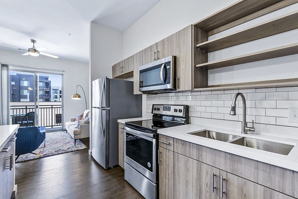 Modern kitchen with stainless steel appliances at West Village Apartments by Greystar