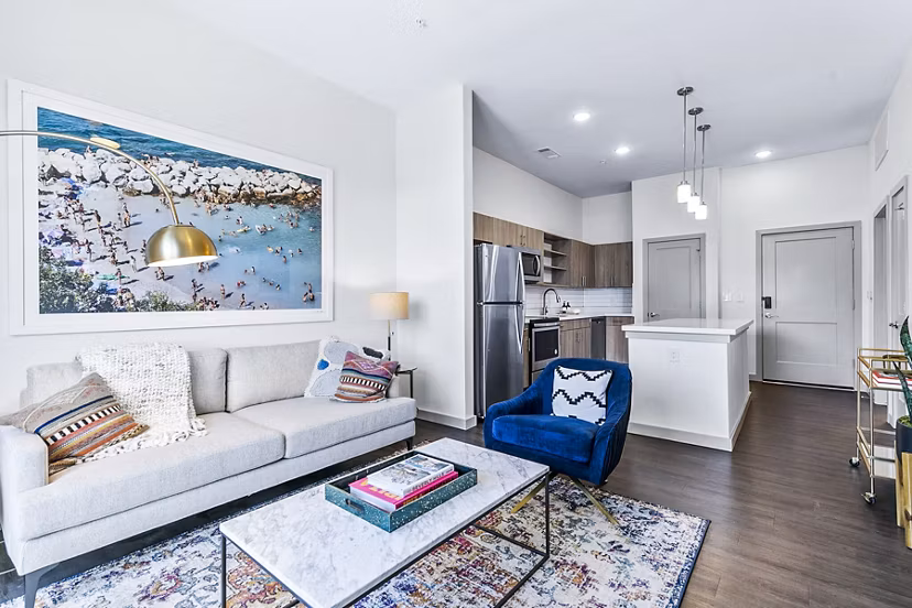 Spacious living room featuring modern decor and cozy seating at West Village Apartments