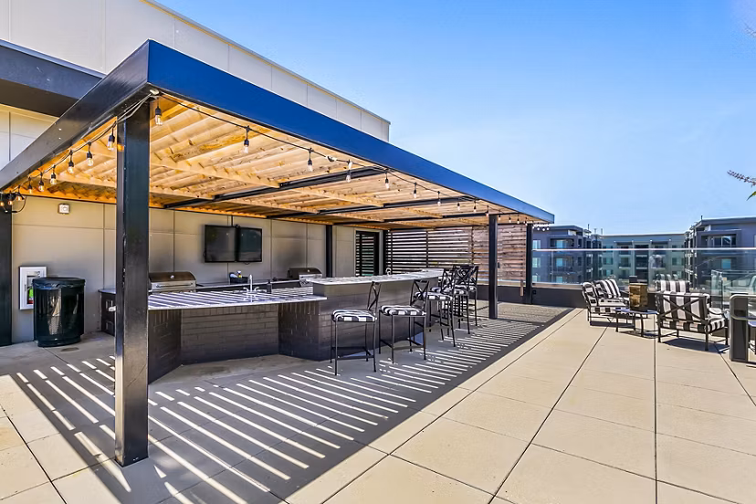 Cozy outdoor grill area at West Village Apartments with modern seating, perfect for gatherings and barbecues