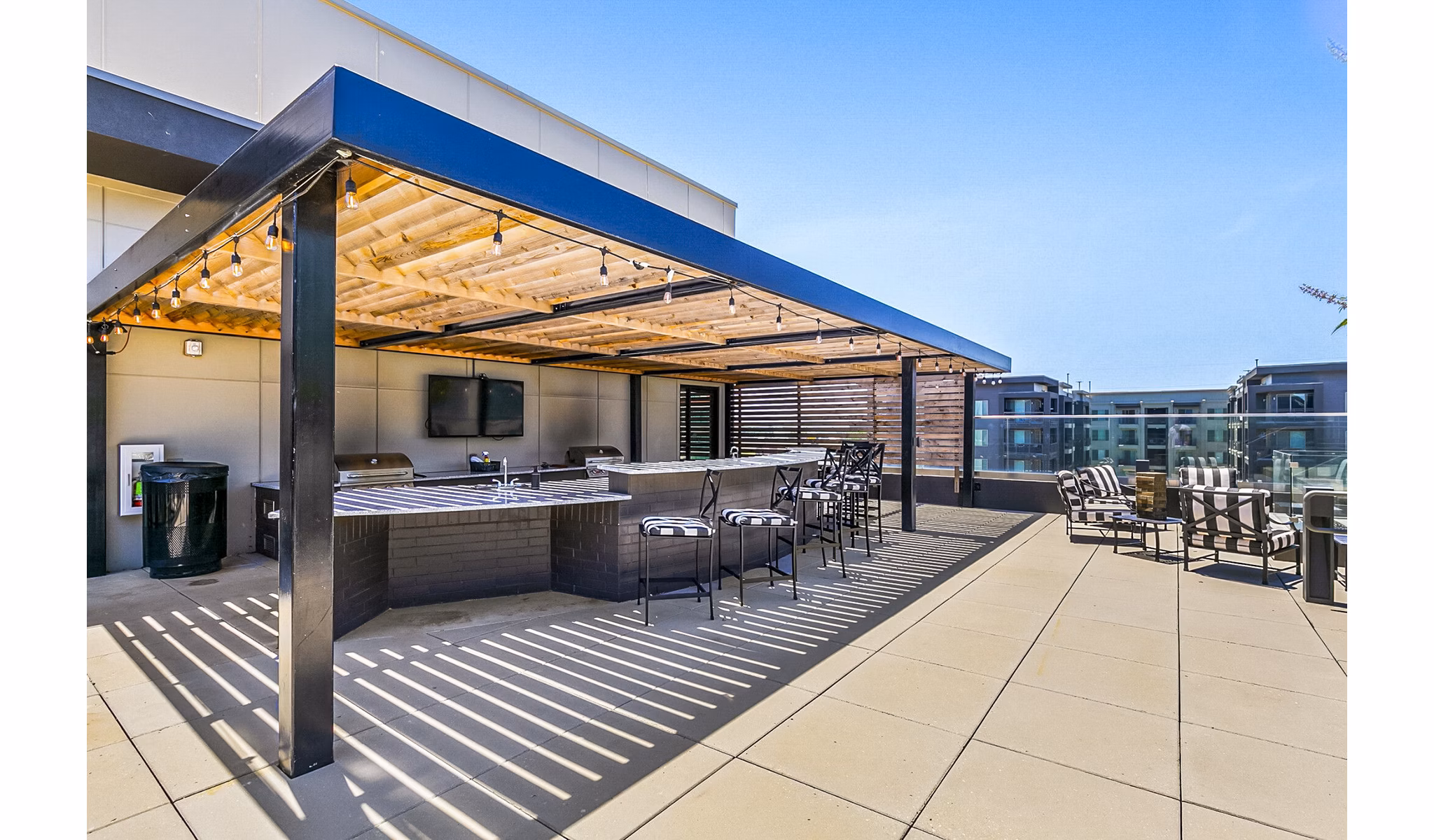 Cozy outdoor grill area at West Village Apartments with modern seating, perfect for gatherings and barbecues