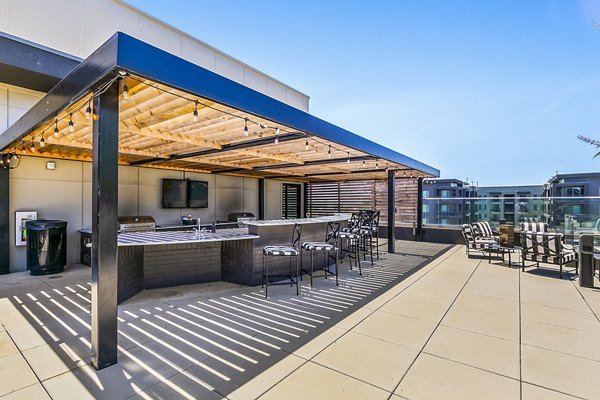 Cozy outdoor grill area at West Village Apartments with modern seating, perfect for gatherings and barbecues