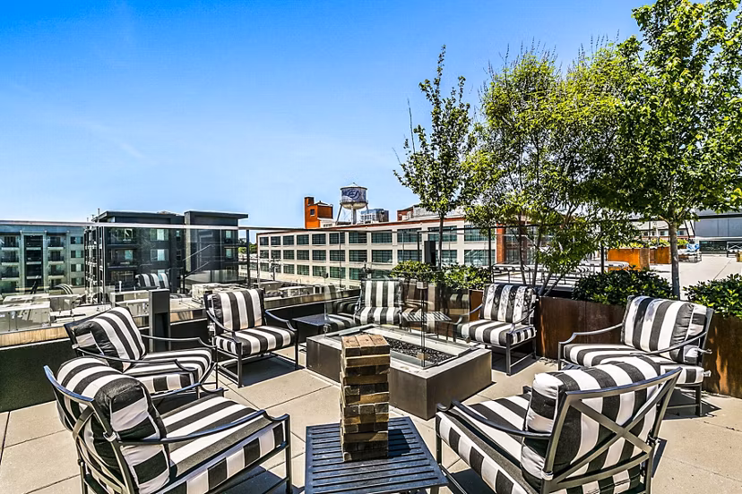 Private patio at West Village Apartments offering scenic garden views and luxury outdoor seating for relaxed living
