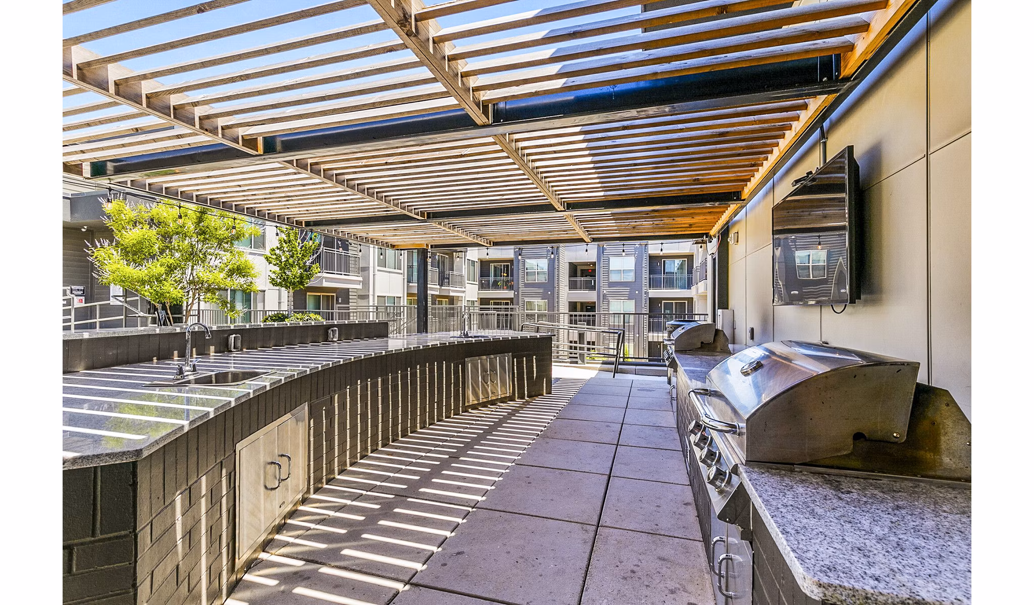 Outdoor grill area with modern seating at West Village Apartments in Houston, ideal for entertaining and relaxation
