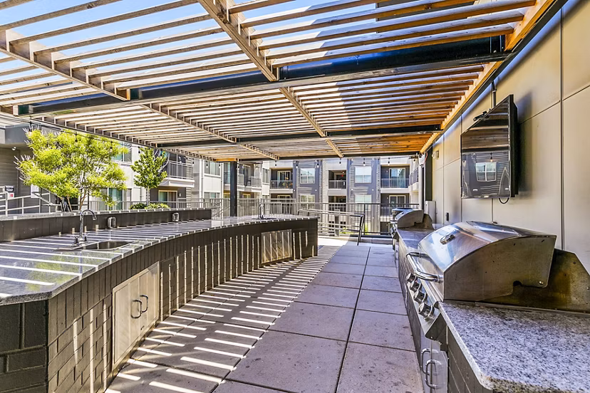 Outdoor grill area with modern seating at West Village Apartments in Houston, ideal for entertaining and relaxation