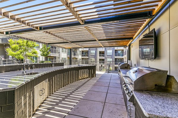 Outdoor grill area with modern seating at West Village Apartments in Houston, ideal for entertaining and relaxation