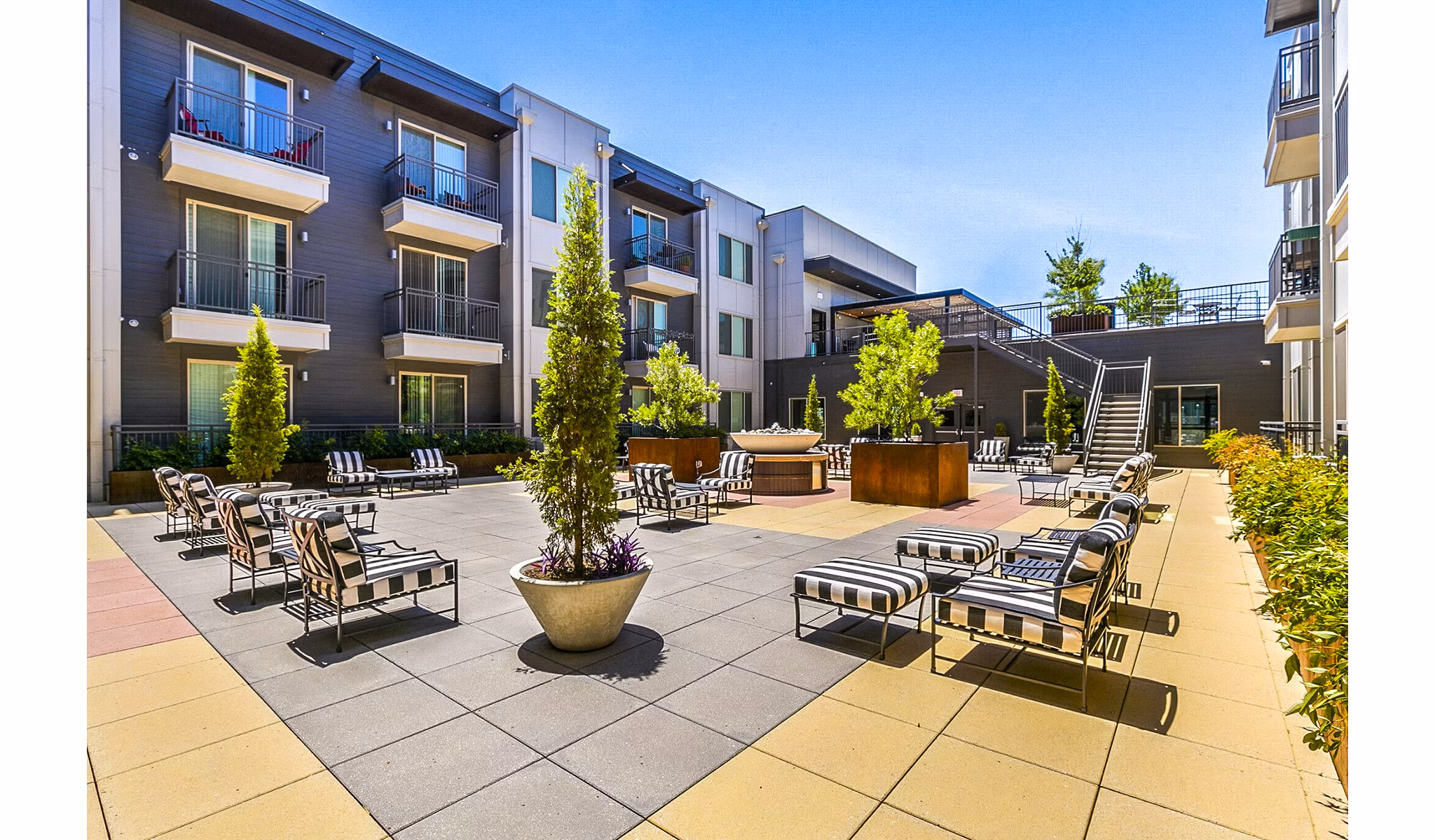 Modern courtyard patio with lush greenery at West Village Apartments, a luxury property by Greystar