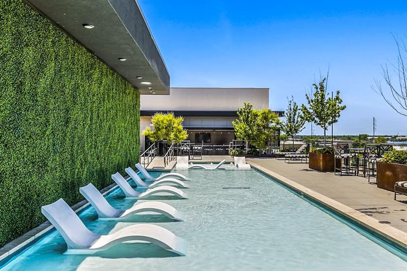 Outdoor pool with lounge chairs at West Village Apartments offering a relaxing space in a luxurious setting
