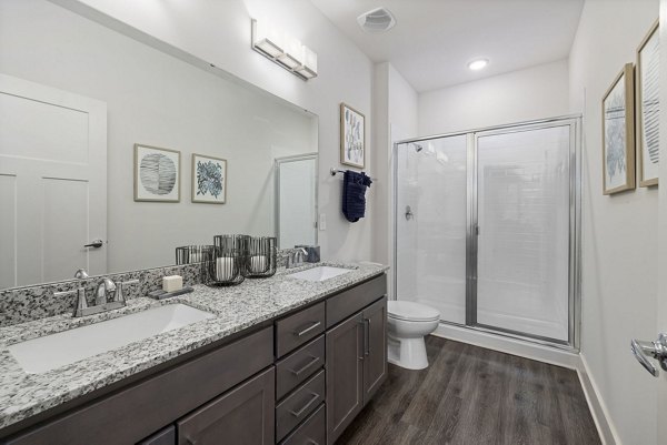 Luxurious bathroom featuring marble countertops and glass shower in The Dakota Apartments