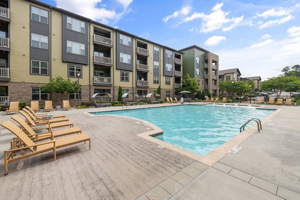 Outdoor pool with sun loungers at The Dakota Apartments offering a relaxing spot for residents to unwind and enjoy sunny days
