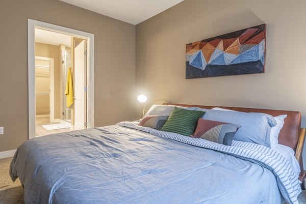 Modern bedroom featuring sleek decor and large windows at Elan Yorktown Apartments