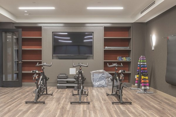 Modern yoga/spin studio with mirrored walls and wooden flooring at Elan Yorktown Apartments in downtown