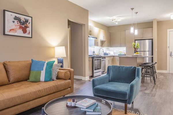 Living room with modern furnishings and large windows at Elan Yorktown Apartments