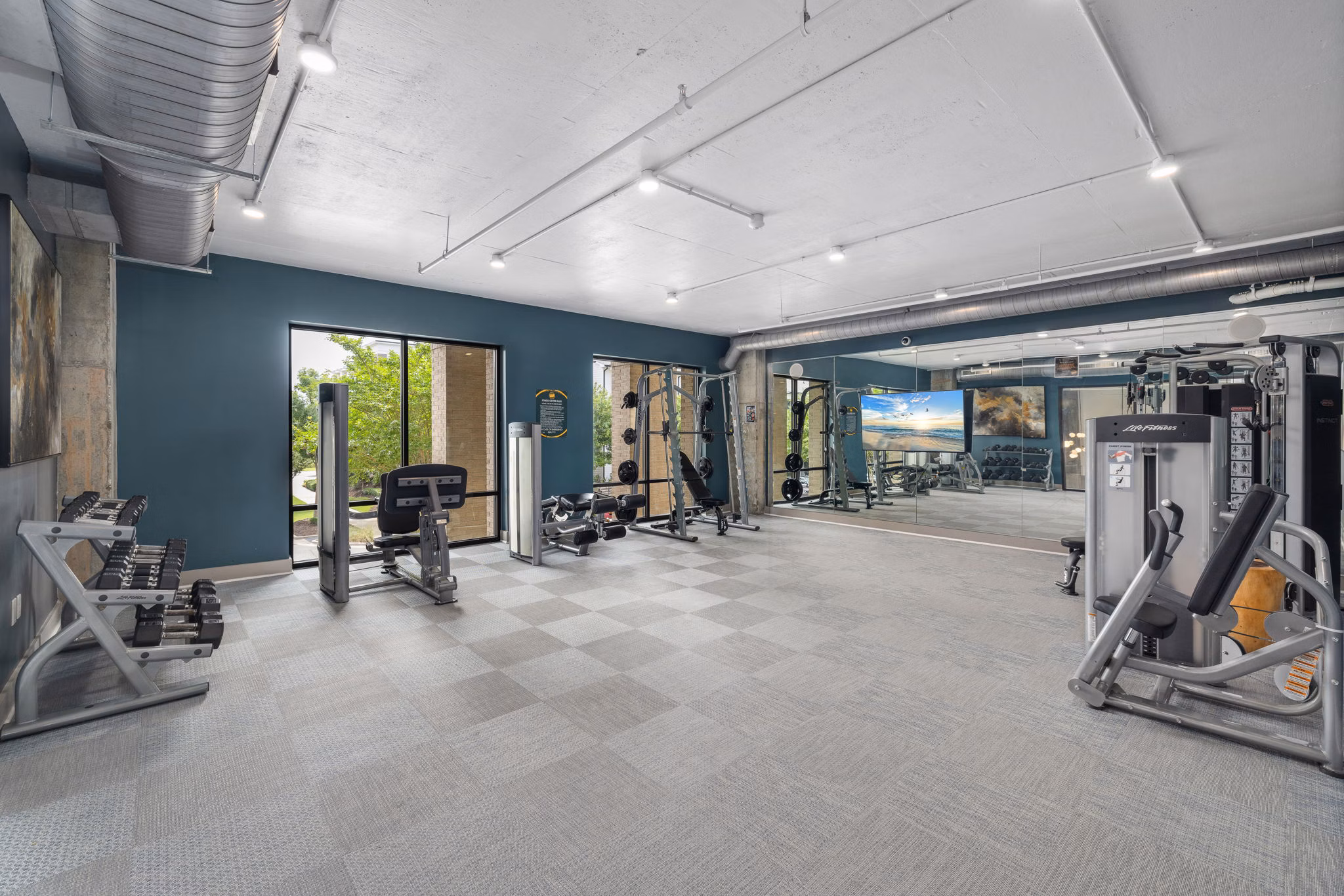 Fully-equipped fitness center at Republic Flats Apartments with modern cardio machines and free weights for residents' wellness and exercise