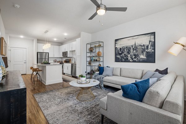 Spacious living room with modern decor and large windows at Republic Flats Apartments