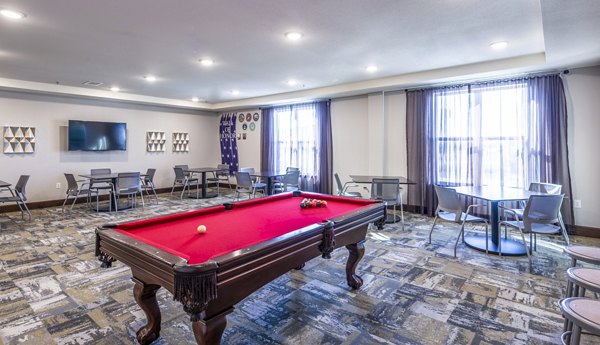 Clubhouse game room featuring pool table and lounge seating at Overture Frisco Apartments, offering luxury living and vibrant social spaces