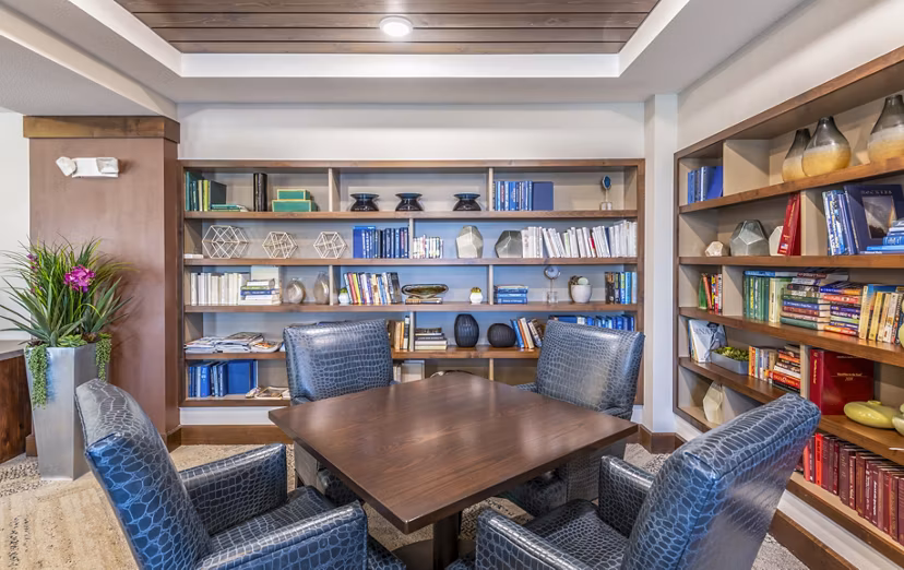 Clubhouse library with modern seating and bookshelves at Overture Frisco Apartments, a luxury living community