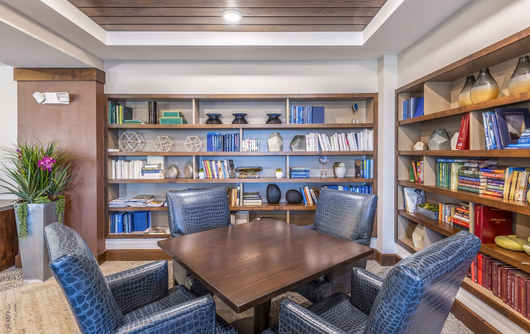 Clubhouse library with modern seating and bookshelves at Overture Frisco Apartments, a luxury living community
