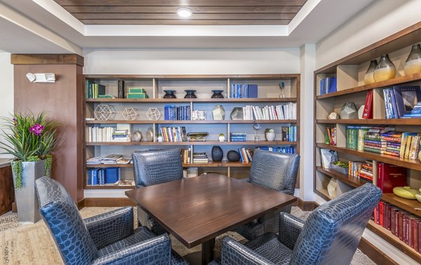 Clubhouse library with modern seating and bookshelves at Overture Frisco Apartments, a luxury living community