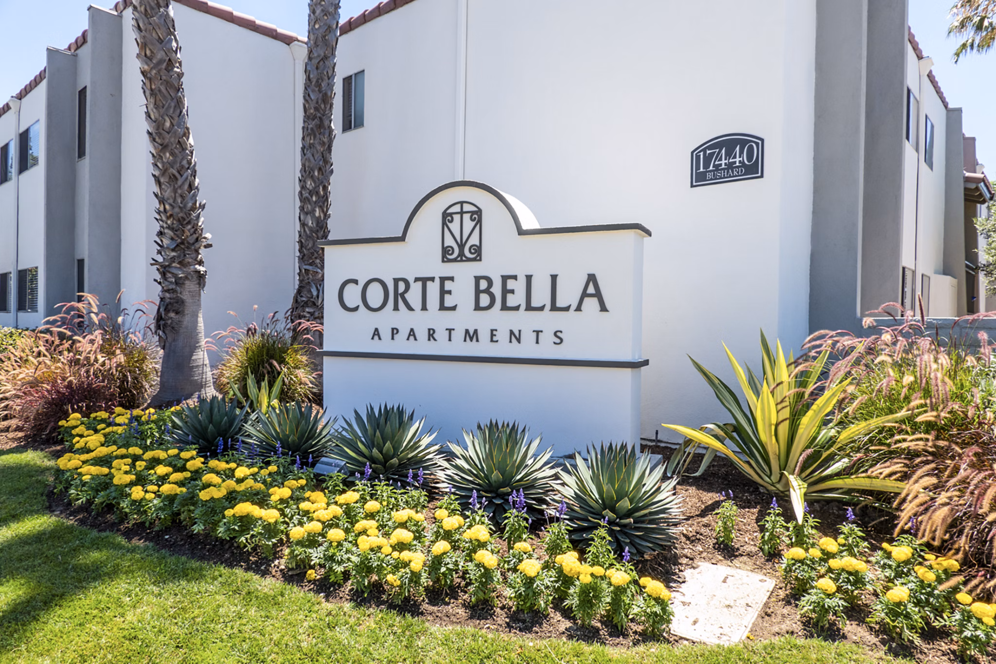 Corte Bella Apartments entrance signage displaying the community name in a lush garden setting
