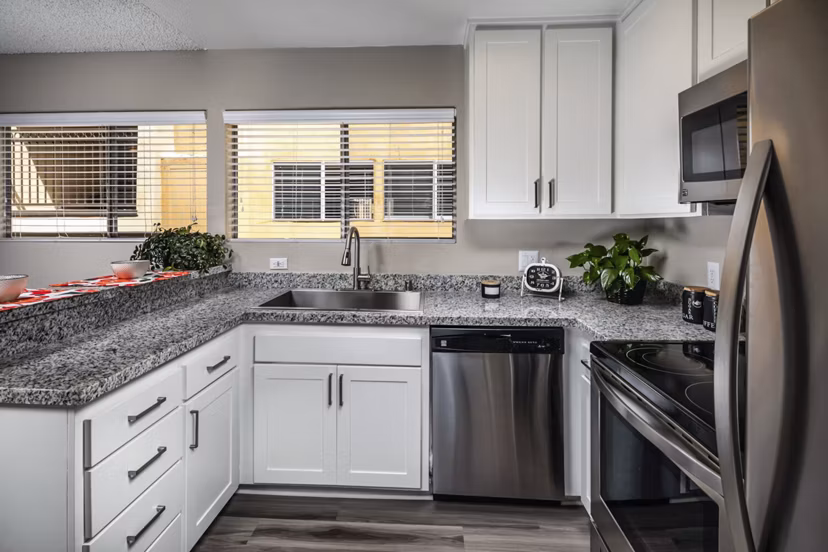 Modern kitchen with dark wood cabinets and a white refrigerator in luxury apartments