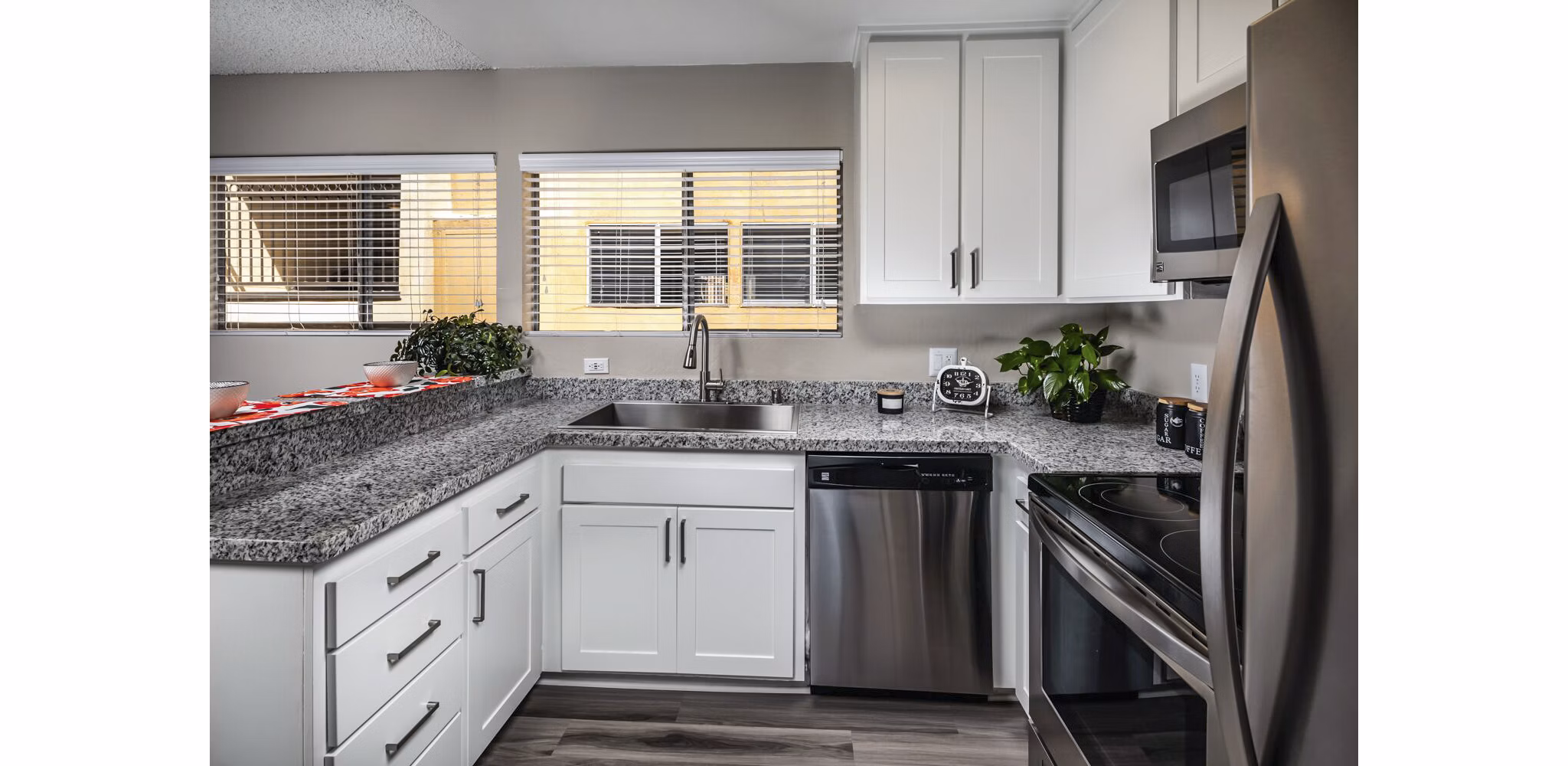 Modern kitchen with dark wood cabinets and a white refrigerator in luxury apartments