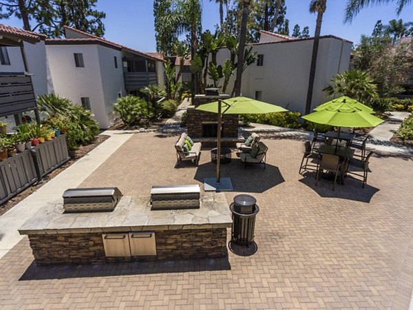 Grill area with modern furniture at Corte Bella Apartments, offering a community-focused outdoor experience in a luxury setting