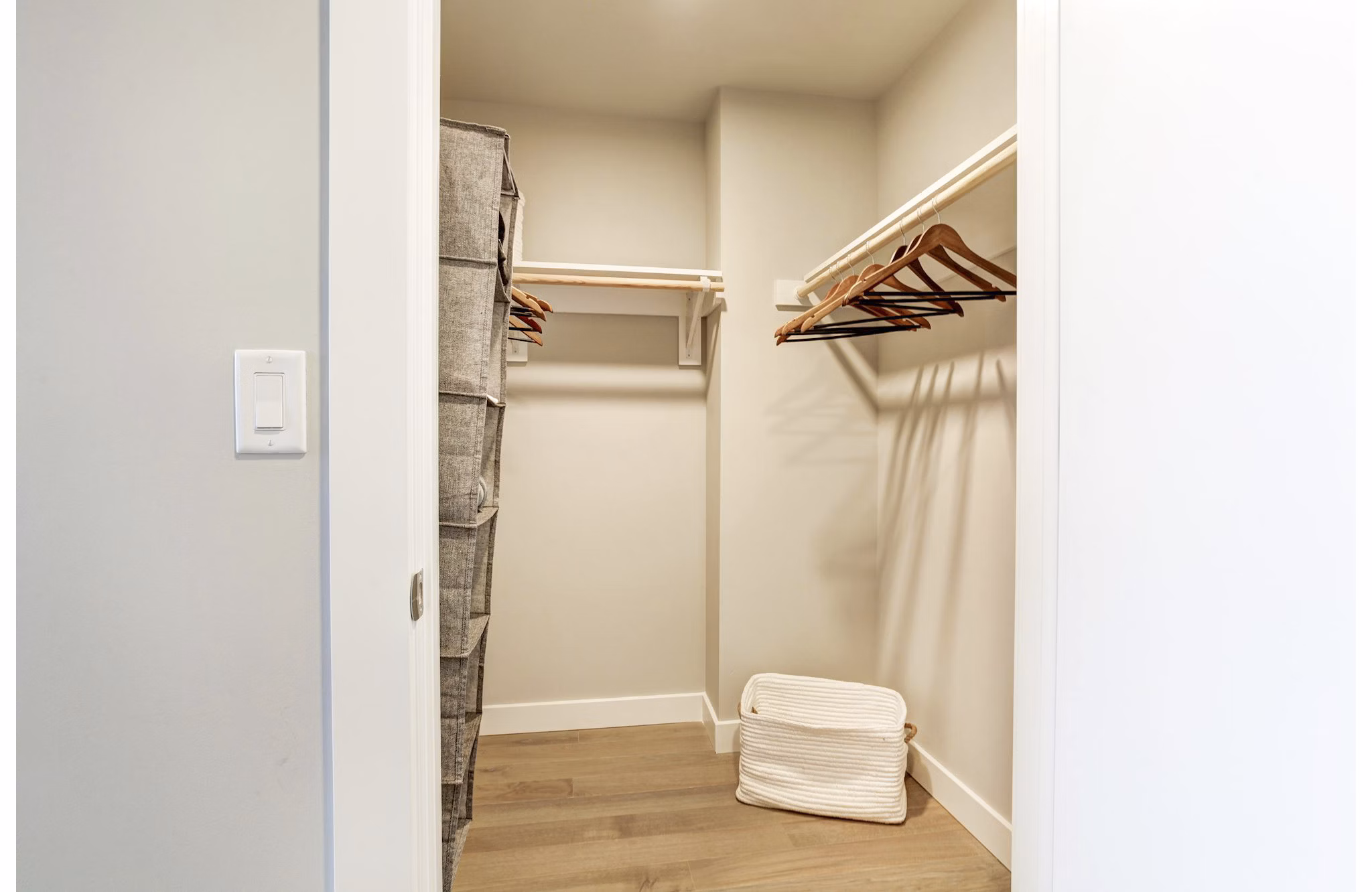 Empty walk-in closet with hangers and storage basket in luxury apartment at Harbor 1500