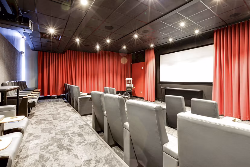 Small private theater with red curtains and gray seats at Harbor 1500 Apartments, luxury living experience in luxury living experience near Greystar luxury apartments