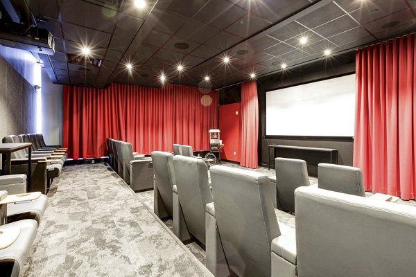 Small private theater with red curtains and gray seats at Harbor 1500 Apartments, luxury living experience in luxury living experience near Greystar luxury apartments