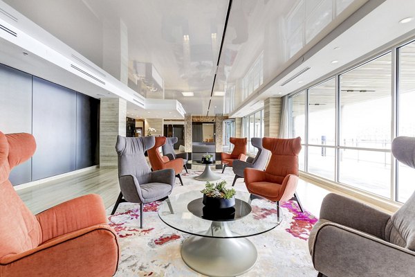 Bright lounge area with colorful chairs and glass tables at Harbor 1500 Apartments in New Jersey