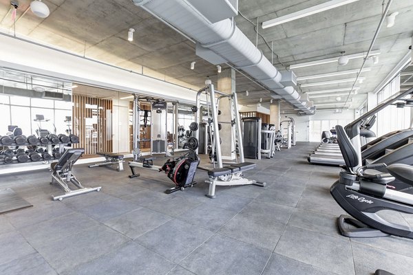 Harbor 1500 Apartments: Spacious gym with exercise equipment and large windows, offering a comprehensive workout space for residents