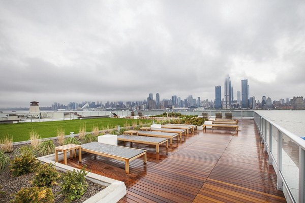 Rooftop terrace with wooden benches offering scenic city skyline views at Harbor 1500 Apartments Perfect for relaxation and social gatherings